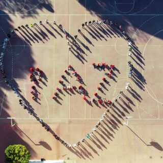 Alumnos formando una silueta de corazón con la palabra paz desde el centro